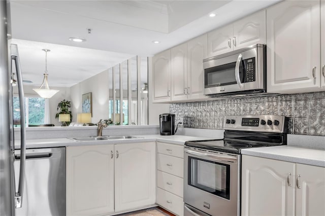 kitchen with a sink, decorative backsplash, light countertops, white cabinets, and appliances with stainless steel finishes