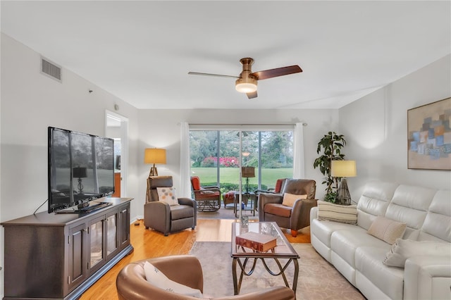 living area featuring visible vents, ceiling fan, and light wood finished floors