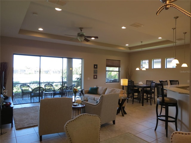 living area featuring visible vents, recessed lighting, and a tray ceiling