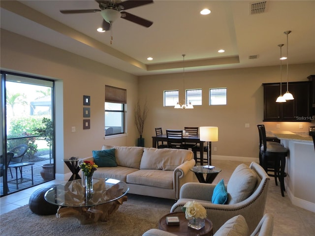 living room with recessed lighting, visible vents, a raised ceiling, and light tile patterned flooring