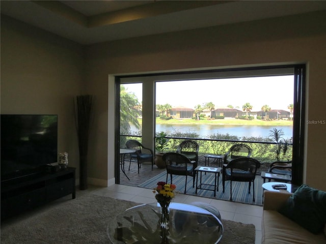 living room with a water view and tile patterned flooring