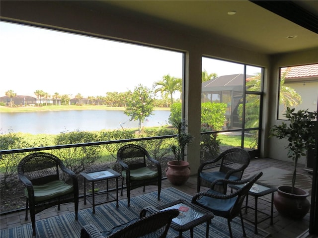 sunroom featuring a water view