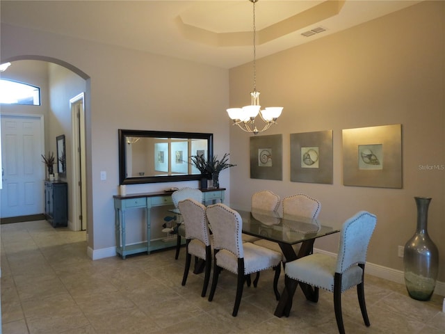 dining area featuring visible vents, arched walkways, baseboards, and a chandelier