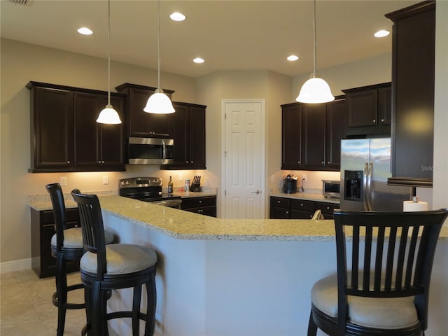 kitchen with recessed lighting, stainless steel appliances, a kitchen breakfast bar, and light stone counters