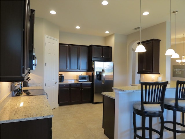 kitchen with visible vents, pendant lighting, recessed lighting, appliances with stainless steel finishes, and light stone countertops