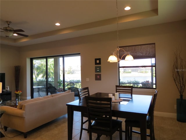 dining room featuring a raised ceiling, light tile patterned floors, and recessed lighting