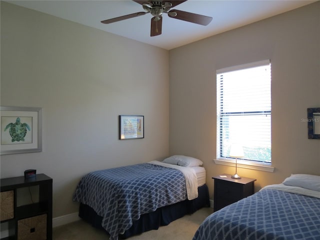 carpeted bedroom with a ceiling fan and baseboards