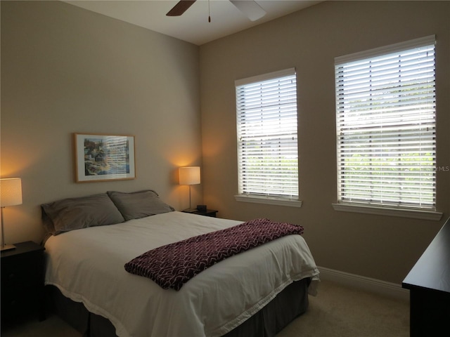 bedroom featuring ceiling fan, baseboards, and carpet