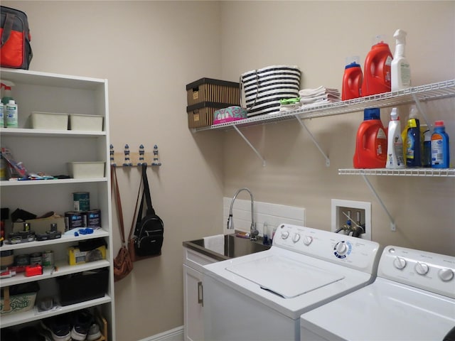 clothes washing area featuring a sink, laundry area, and washing machine and clothes dryer