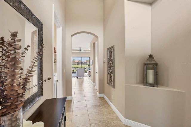 1290 Cielo Ct, North Venice, FL 34275 - corridor with arched walkways, light tile patterned flooring, baseboards, and a towering ceiling