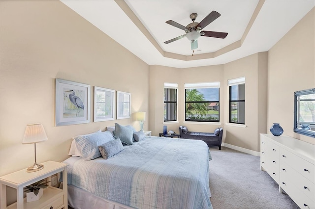 1290 Cielo Ct, North Venice, FL 34275 - bedroom featuring light carpet, a raised ceiling, baseboards, and ceiling fan