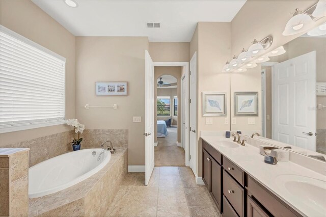 1290 Cielo Ct, North Venice, FL 34275 - ensuite bathroom with a bath, double vanity, ceiling fan, and baseboards