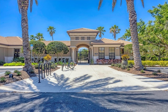 1290 Cielo Ct, North Venice, FL 34275 - view of front of home featuring stucco siding, a tiled roof, and a gate