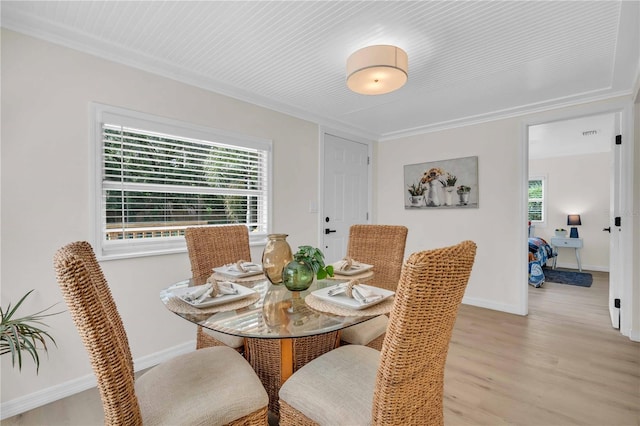 dining space with plenty of natural light, light wood-style floors, baseboards, and ornamental molding