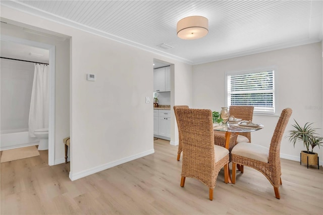 dining space featuring light wood-style flooring and baseboards