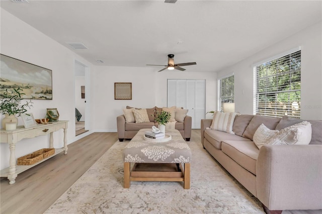 living area featuring visible vents, a ceiling fan, and light wood-type flooring