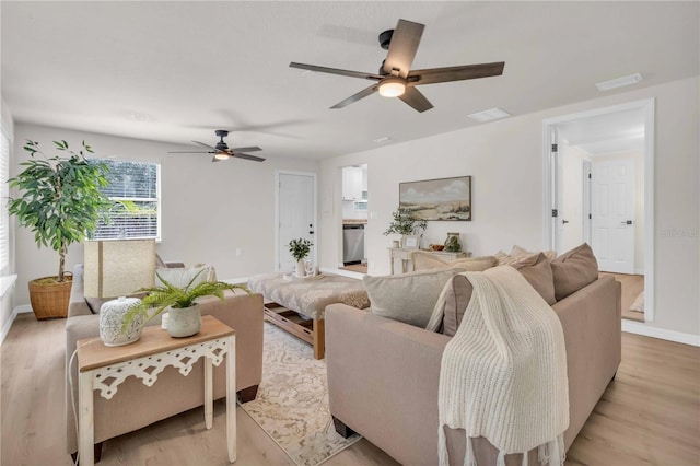 living room featuring a ceiling fan, light wood-style flooring, baseboards, and visible vents