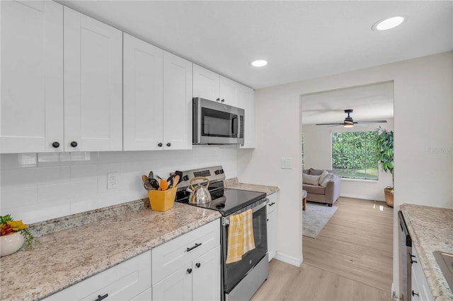 kitchen featuring recessed lighting, light wood-style floors, appliances with stainless steel finishes, white cabinets, and baseboards