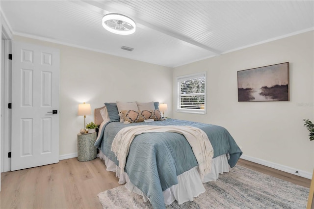 bedroom featuring wood finished floors, visible vents, and baseboards