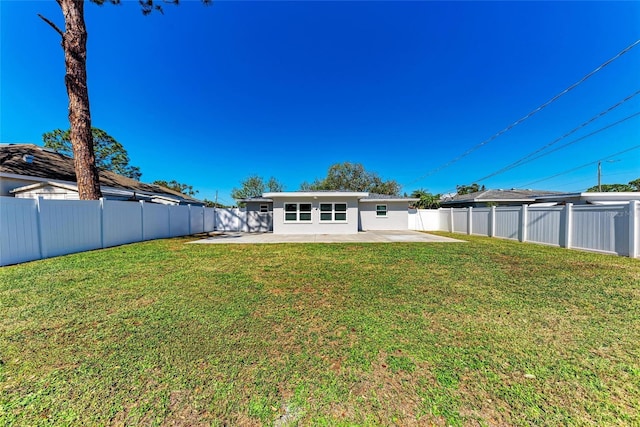 back of house with a patio area, a fenced backyard, stucco siding, and a yard