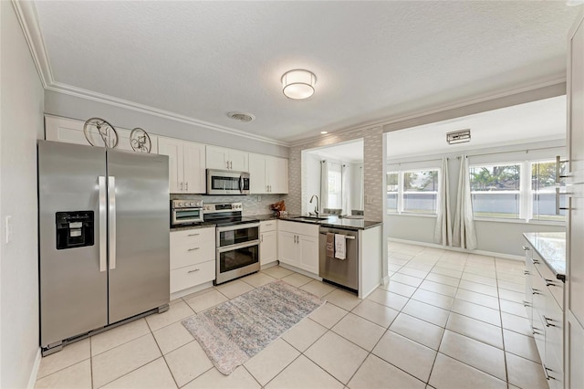 kitchen featuring light tile patterned floors, visible vents, ornamental molding, a sink, and appliances with stainless steel finishes