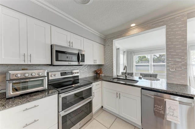 kitchen featuring a sink, stainless steel appliances, crown molding, and white cabinetry