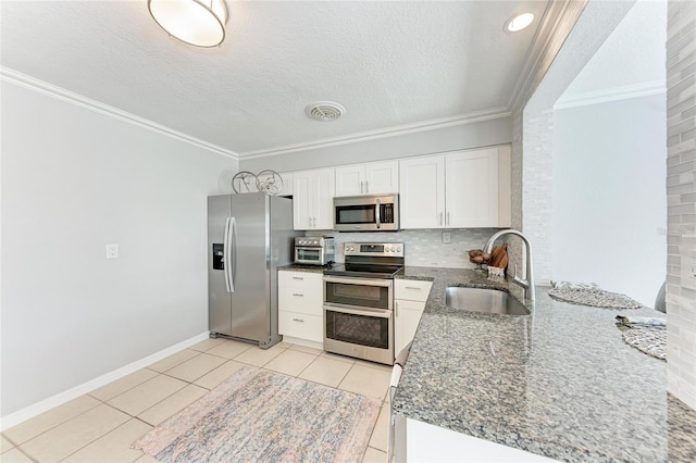 kitchen featuring a sink, stainless steel appliances, ornamental molding, and white cabinets