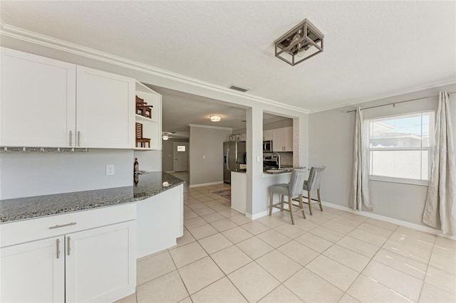 kitchen with light tile patterned floors, open shelves, ornamental molding, stainless steel appliances, and white cabinets