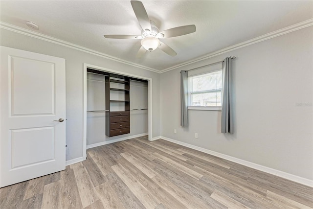 unfurnished bedroom with a ceiling fan, baseboards, light wood-style flooring, a closet, and crown molding