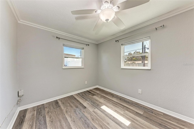 spare room with ornamental molding, a textured ceiling, wood finished floors, baseboards, and ceiling fan