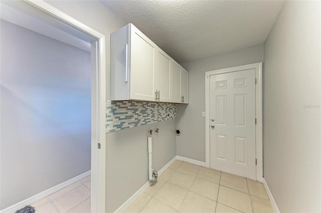 washroom featuring light tile patterned floors, cabinet space, hookup for a washing machine, and baseboards