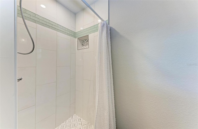 full bath with a shower stall and a textured wall