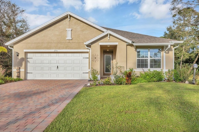 view of front of property with decorative driveway, a front yard, and stucco siding