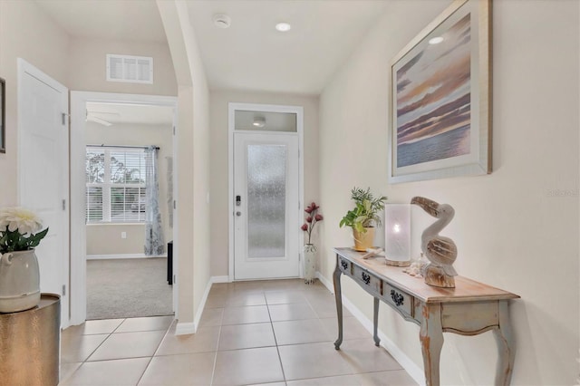 foyer entrance featuring light tile patterned floors, visible vents, and baseboards