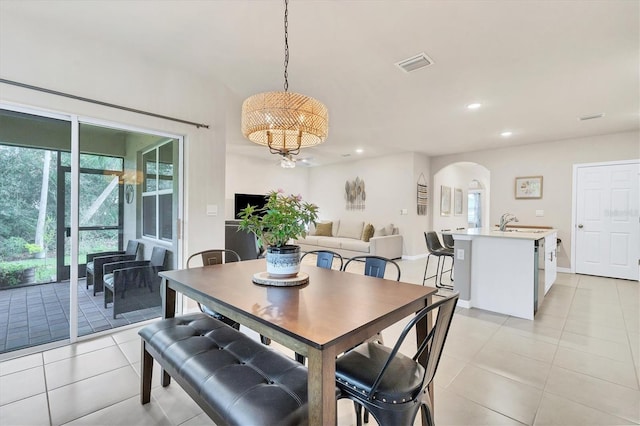 dining area with arched walkways, light tile patterned floors, recessed lighting, visible vents, and baseboards