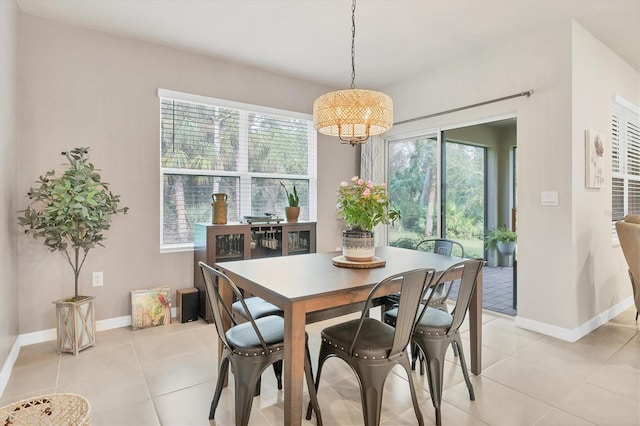 dining room with plenty of natural light, light tile patterned flooring, and baseboards