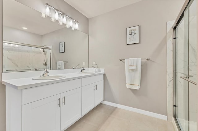 bathroom featuring a sink, a shower stall, baseboards, and tile patterned floors