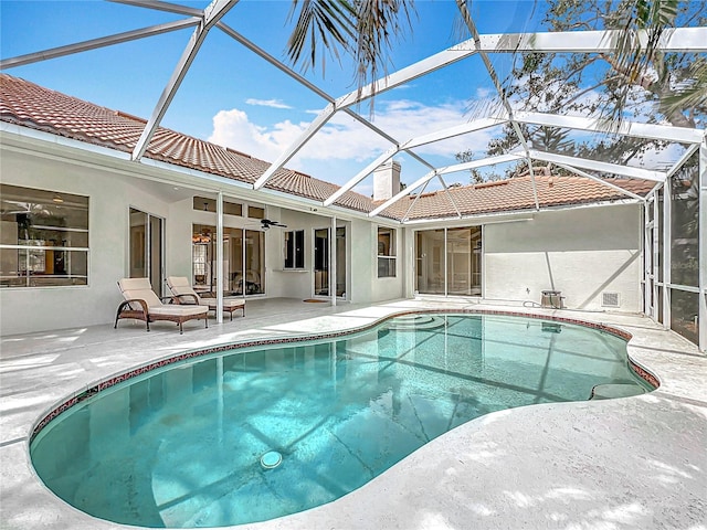 outdoor pool featuring a patio, a lanai, and a ceiling fan