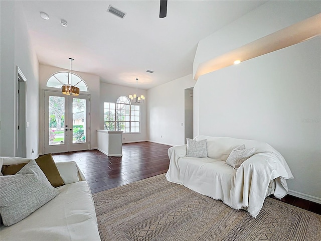 living room with french doors, dark wood-type flooring, a notable chandelier, and visible vents