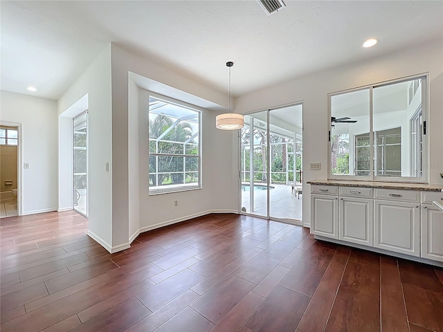 unfurnished dining area with recessed lighting, baseboards, dark wood finished floors, and ceiling fan