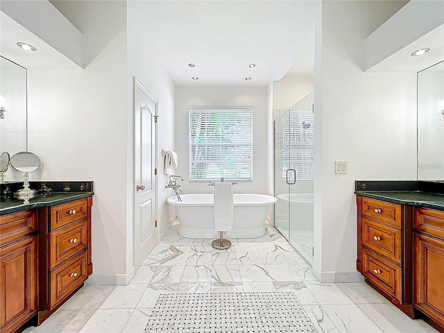 bathroom with a freestanding tub, marble finish floor, a stall shower, and vanity