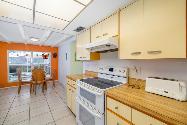 kitchen featuring light tile patterned floors, double oven range, visible vents, butcher block countertops, and under cabinet range hood