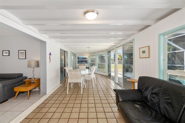 sunroom / solarium featuring beam ceiling and a healthy amount of sunlight