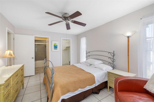 bedroom featuring light tile patterned floors, ceiling fan, a closet, a walk in closet, and connected bathroom