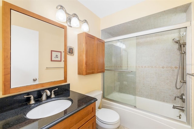 bathroom with combined bath / shower with glass door, toilet, and vanity