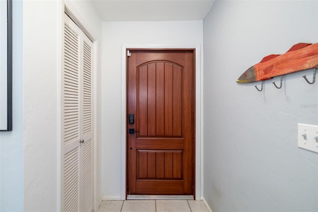 doorway to outside with light tile patterned floors and baseboards