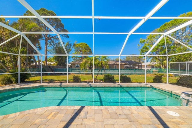 view of swimming pool with a patio area, glass enclosure, a fenced in pool, and fence