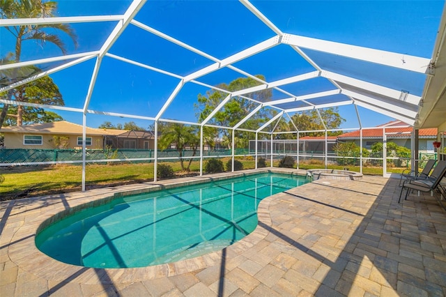 view of pool with glass enclosure, a patio, and a pool with connected hot tub