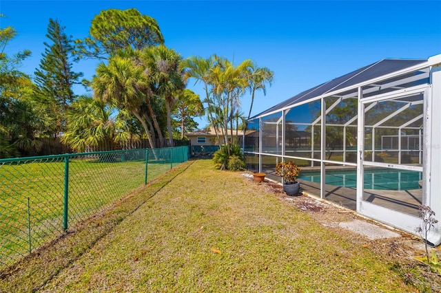 view of yard featuring glass enclosure, a fenced in pool, and a fenced backyard