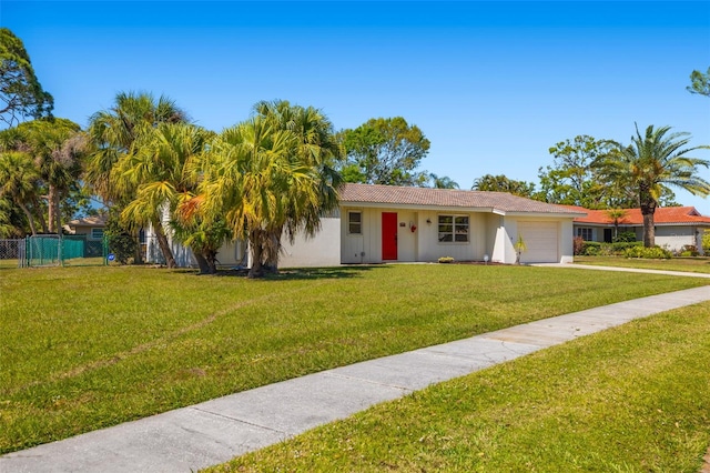 single story home featuring a front yard, fence, and a garage